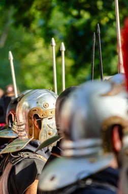 detail of the helmets of Roman legionary soldiers in formation at a historical reenactment party on ancient Rome. clipart