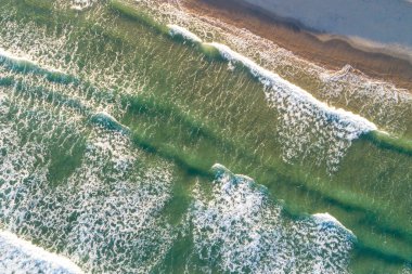 Yüksek gelgitlerin olduğu bir günde, kumsalın kıyısındaki dalgaların hemen üstündeki drone antenleri.