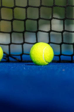 Mavi raket tenis kortu, kalenin yanındaki iki topun görüntüsü. Seçici odaklanma. Raket sporu arka planı