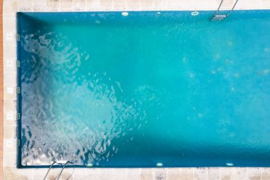 Bir tatil tesisinde turkuaz yüzme havuzunun insansız hava aracı görüntüsü, yaz tatili konsepti arka planı.