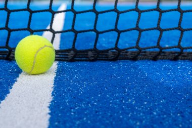 Mavi raket tenis kortunun yanındaki çizgide raket tenis topu.