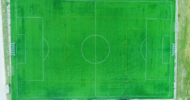 Futbol sahasının merkezindeki havadan kumandalı hava aracı görüntüsü oyuncuları çalıştırıyor.