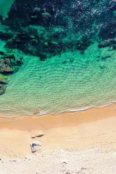 Suyun kenarındaki kum ve kayaların drone fotoğrafçılığı. Havadan insansız hava aracı aşağı bakıyor. Arkaplan plaj konsepti dokusu