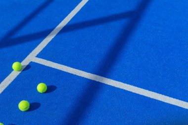 Mavi raket tenis kortunda üç top, raket spor arka planı konsepti