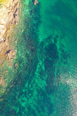 Zıt plaj elementleri: kum ve kayalık kıyı şeridi. Yukarıdan aşağıya hava aracı görünümü