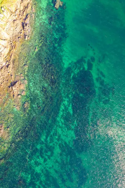 Zıt plaj elementleri: kum ve kayalık kıyı şeridi. Yukarıdan aşağıya hava aracı görünümü