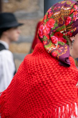 Geleneksel Galiçya tarzı giyinmiş bir kadın folklorik bir festivalde sırtını döndü.