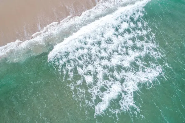 Turkuaz su ve dalga köpüğünün insansız hava aracı fotoğrafçılığı.