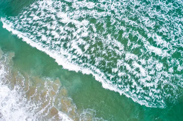 Kıyıdaki bir dalganın insansız hava aracı görüntüsü.