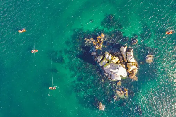 Zenital hava aracı kıyıya yakın turkuaz sularda balıkçılık yapan balıkçı teknelerini görüyor. Geleneksel deniz balıkçılığı