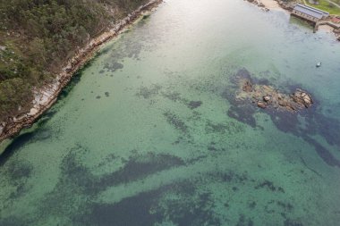Doğal kayalık kıyı manzarasının havadan bakış açısı, berrak su. Rias Baixas, Galiçya