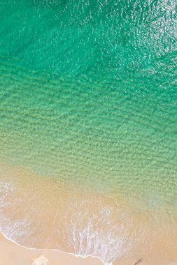 Sahil kıyısında el değmemiş turkuaz suları ve altın kumu var. İHA 'lı havadan yukarıdan aşağı görünüm, tropik yaz konsepti için arka plan.
