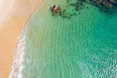 Turkuaz deniz yüzeyi ve hafif kum, hava sahili fotoğrafçılığı.
