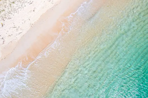 Sahil kıyısında el değmemiş turkuaz suları ve altın kumu var. İnsansız hava aracı ile yukarıdan görünüşü, tropikal yaz konsepti için arka plan.