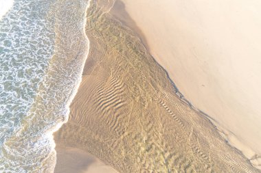 Doğal kum desenlerinin ve su kaynaklı dokuların havadan görünüşü, yukarıdan aşağıya bakan dron görüntüsü