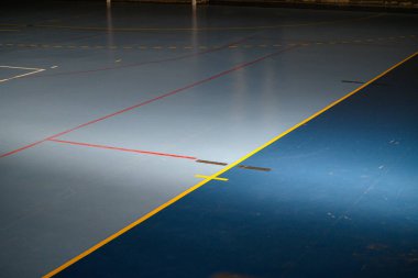 Profesyonel spor salonu, kırmızı, sarı ve beyaz oyun çizgileri olan mavi yüzey. Futsal ya da hentbol