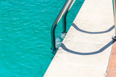 Canlı turkuaz su dokusuna karşı paslanmaz çelik korkuluklar.