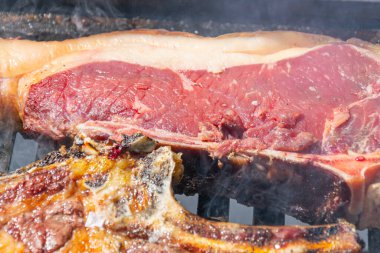 Cızırdayan T-bone bifteği ve ızgarada pişen kaburgalara yakın durun.