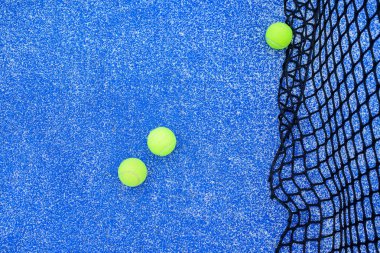 Tenis kortunun detaylarını ve oyun sahasındaki parlak yeşil topları.