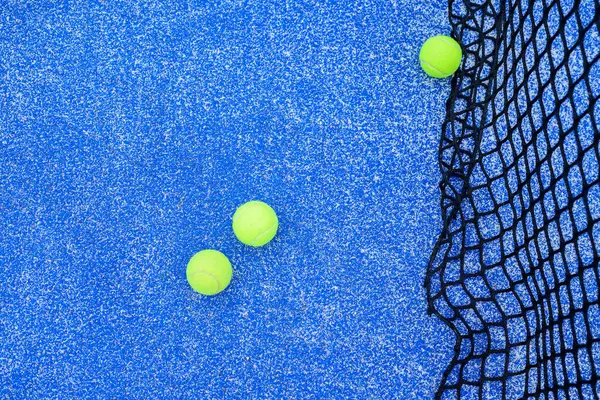 Tenis kortunun detaylarını ve oyun sahasındaki parlak yeşil topları.