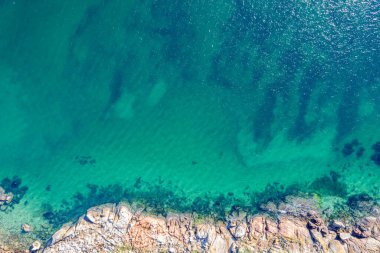 Sakin okyanus turkuvaz su dokusu ve kayalık sahil plajı, İHA Perspektifi