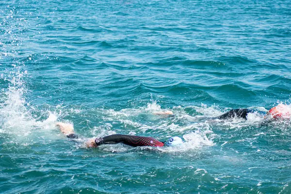 İki sporcu açık denizde yüzme yarışında yarışıyor.