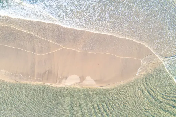 İnsansız hava aracı, el değmemiş bir sahil şeridindeki karmaşık beyaz köpük desenlerini yakalıyor.