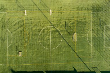 Gün batımında futbol antrenman sahasının insansız hava aracı görüntüsü.
