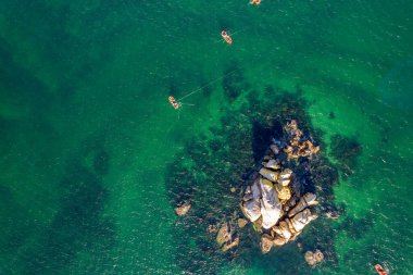 Yukardan gelen kayalar ve botlarla el değmemiş deniz manzarası. Yukarıdan aşağıya insansız hava aracı görünümü