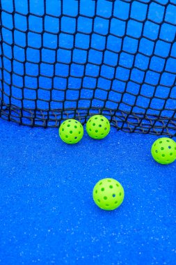 Mavi Saray 'da Net' ten Yeşil Pickleball topları. Oyunun merkezi hareket alanını kavra.