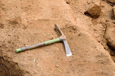 Bir kazı alanında, yerde küçük bir kazma aleti var. Kavram Keşif için temel araç.
