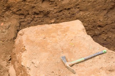 Arkeolojik Kazı Alanında Büyük Taş Üstünde Kazma. Kavram Büyük bir keşfin meydan okuması.
