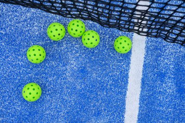 Mavi arka planda topları ve ağı olan Pickleball spor konsepti.