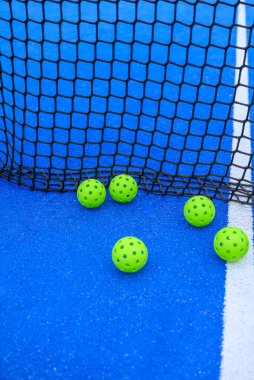 Pickleball topları antrenman için kalenin yanına dizildi..