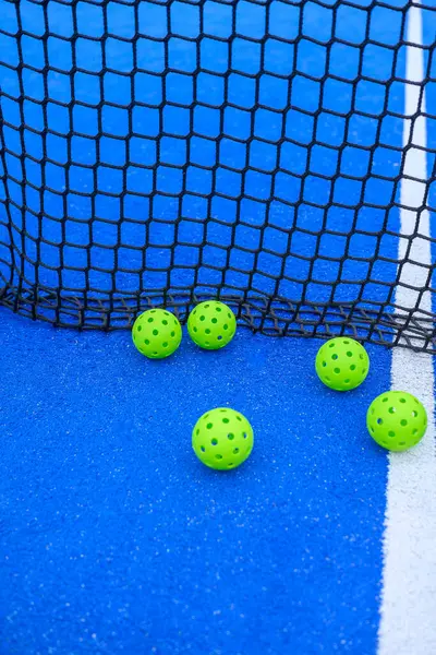 Pickleball topları antrenman için kalenin yanına dizildi..