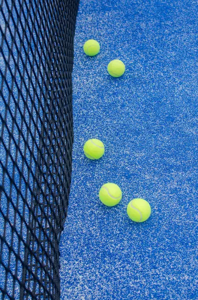Padel topları antrenman için ağın yanına dizildi..