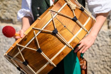 Geleneksel ahşap davul taşıyan ortaçağ kostümlü bir müzisyen. Halk Müziği