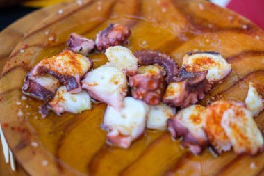 Ahşap bir tahtanın üzerinde bir ahtapot yemeği. Geleneksel mutfağın cazibesini kavra. Pulpo a feira