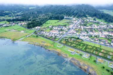Büyük bir gölün kıyı şeridi Bulutlu bir günde. Doğanın dramatik güzelliğini kavra. Azores 'deki Sete Cidades ya da Furnas Gölü