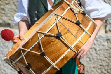 Geleneksel bir ahşap davul ve tokmak. Müzisyen tarafından tutulmuş, tarihi bir halk müziği.