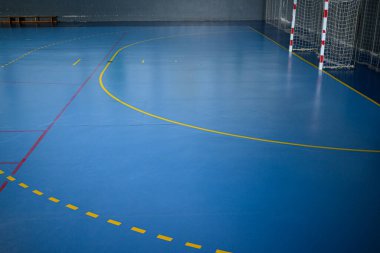 Mavi zemin ve sarı çizgiler takım spor konsepti olan boş bir hentbol sahası