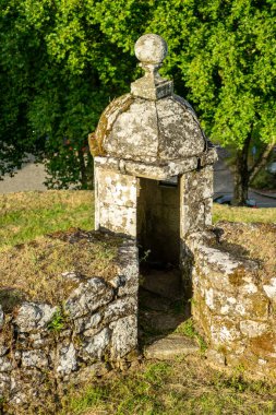 Taş duvarları ve yeşil çimleri olan antik askeri mimari.