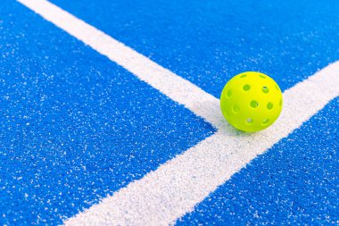 Mavi kortun beyaz çizgileri üzerinde dinlenen parlak sarı bir yankesicilik yeni bir spor eğilimi konsepti.