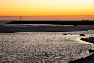Huzurlu ve sakin bir sahil gün batımı ufukta dalgalı bir siluet ve huzur dolu bir kaçış konsepti