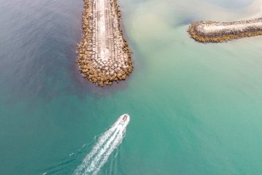 Limandan ayrılan bir sürat teknesinin hava görüntüsü, bir yolculuk konsepti başlatır..