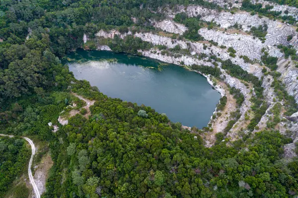 Sisli ve puslu bir günde eski bir taş ocağında gizli bir göl manzarası. Gizemli doğa kavramı.