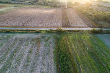 Sunset 'teki bir tarlada çalışan bir traktörün hava aracı görüntüsü. Kavram Çiftçi Günü 'nün sonu.