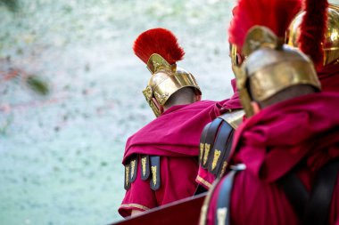 Arkadan görülen bir grup Romalı savaşçı. Bir ordunun anonim gücünü kavra..