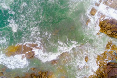 Denizin Evcilleştirilmemiş Gücü kayalık bir kıyıda desenler oluşturuyor.