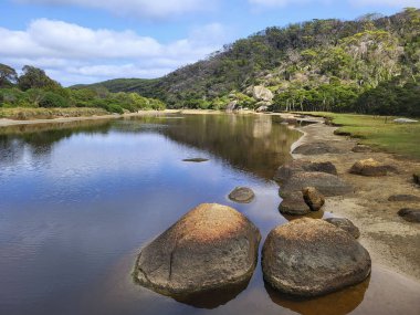 Wilsons Promontory Ulusal Parkı 'ndaki Norman Sahili' ne akan gelgit nehrinin kıyısındaki granit kayalar..